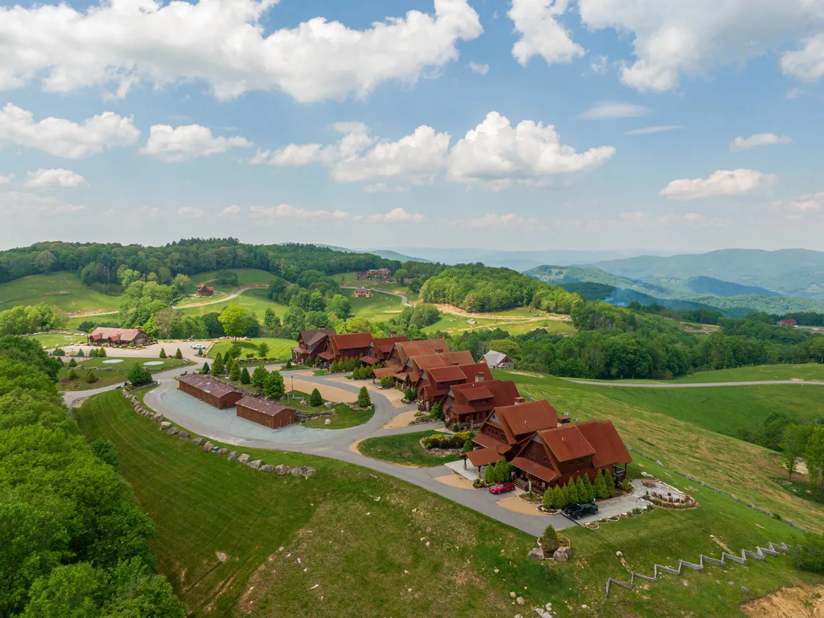 A tranquil exterior view showcasing log cabins nestled among landscaped gardens, with a winding road connecting the cabins. The scene suggests opportunities for hiking, outdoor gatherings, and nature walks, and hints at the privacy and community balance described in the section.